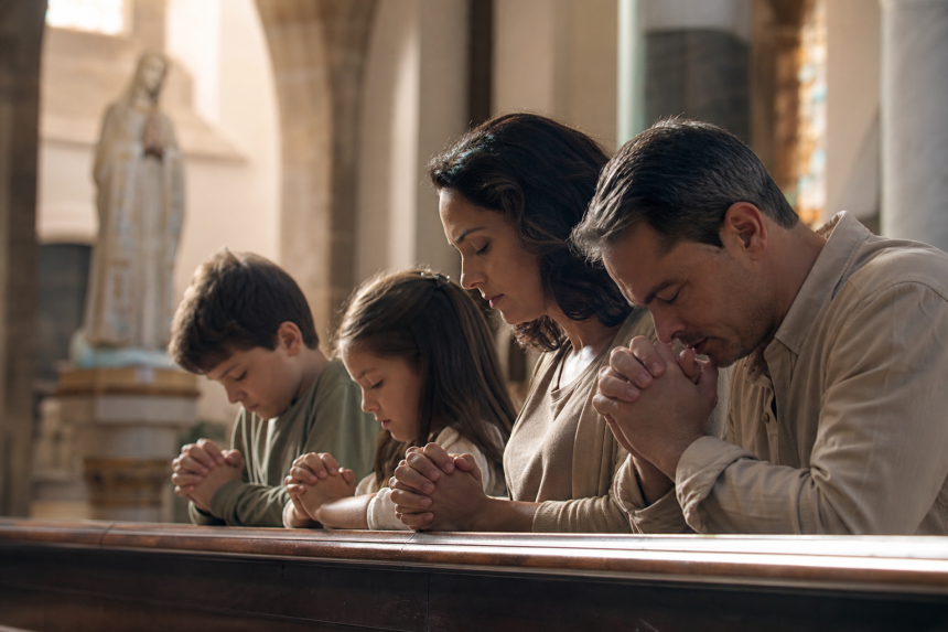 Família participa de momento de oração em uma igreja católica