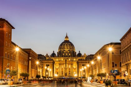 Basílica de São Pedro iluminada ao entardecer, em Roma.